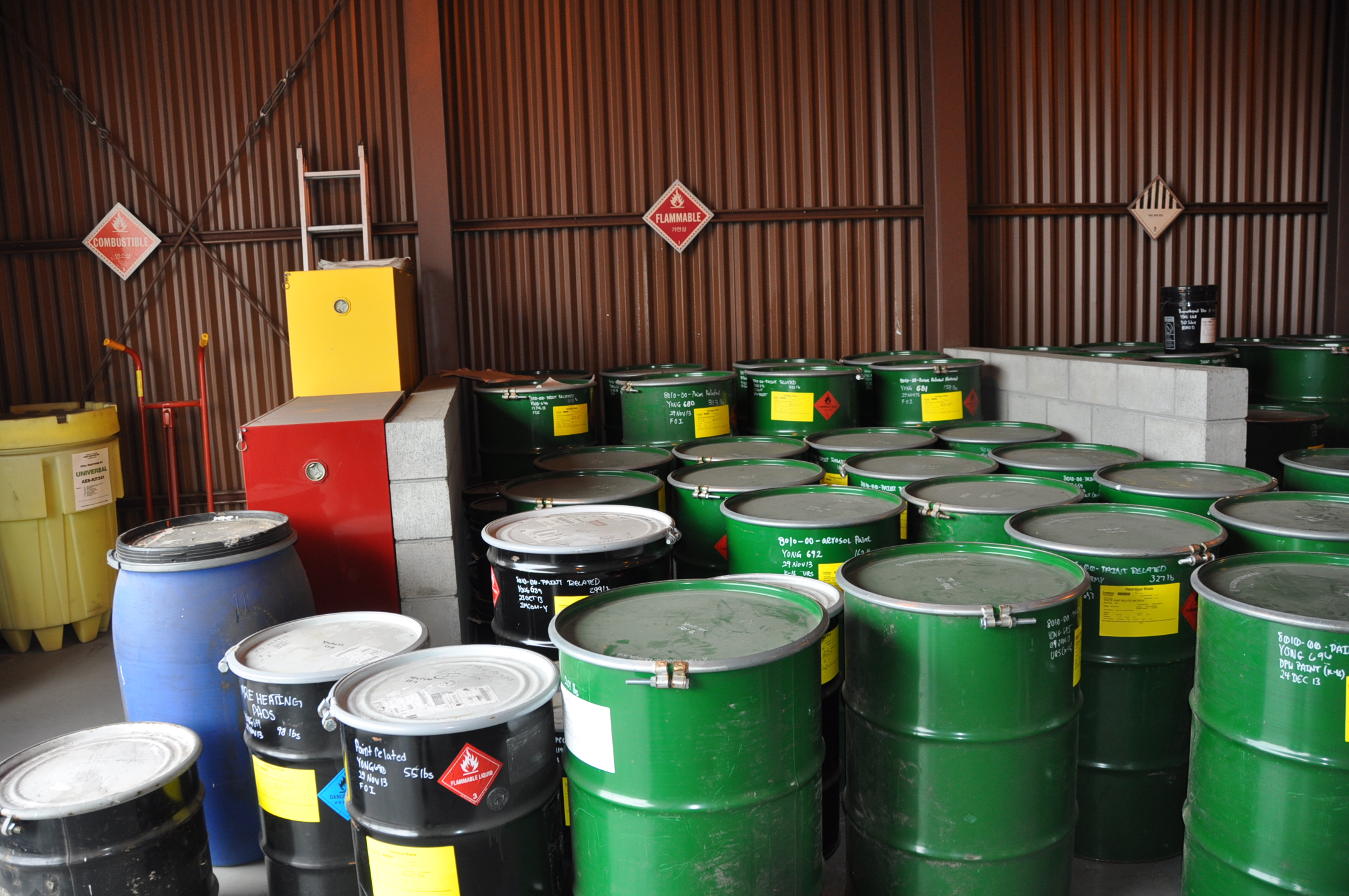 Hazardous material storage room with various containers of hazardous materials and labeling
