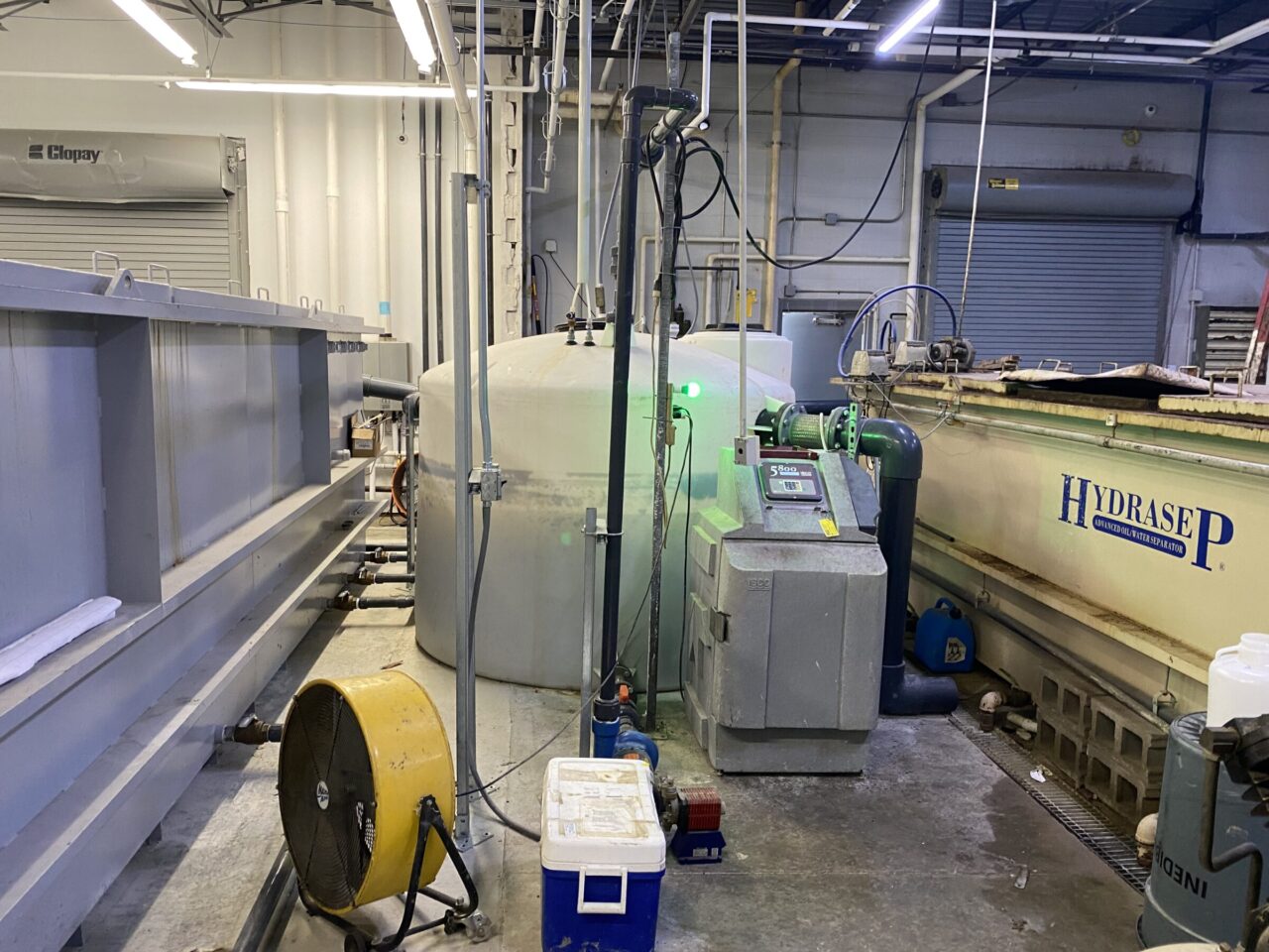 Wastewater pretreatment equipment inside a food production facility, showing tanks, piping, and filtration infrastructure for regulatory compliance.